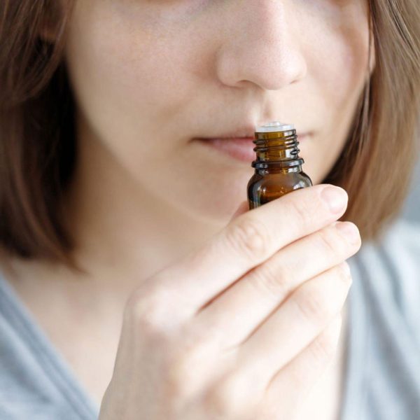 Pessoa a inalar óleo essencial representando resposta individual aos aromas